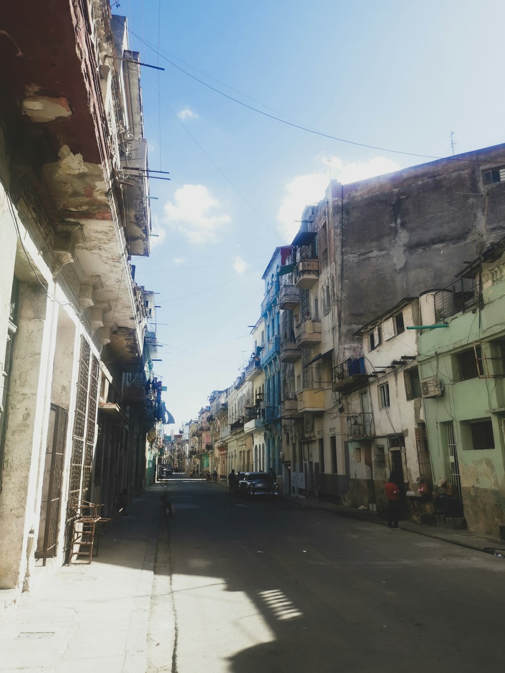 a man walking down a street next to tall buildings