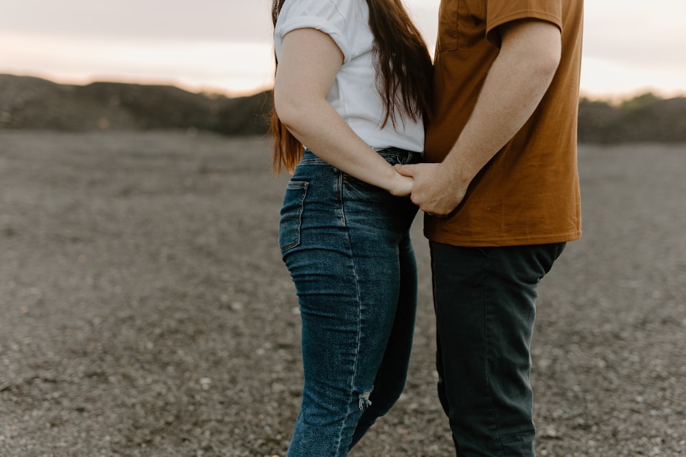 a man and a woman standing in the middle of a field