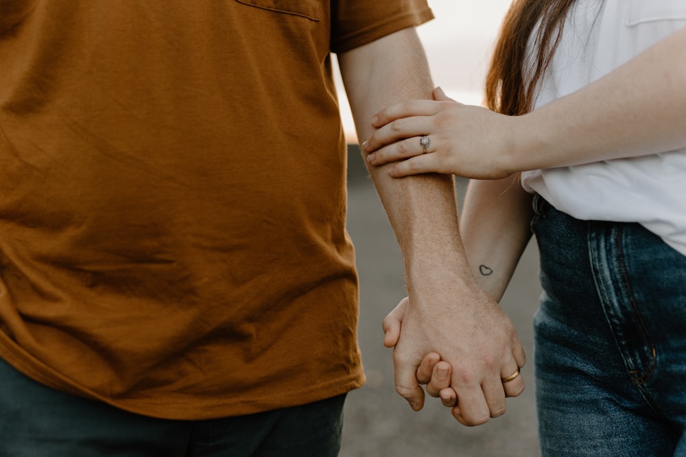 a close up of a person holding the hand of another person