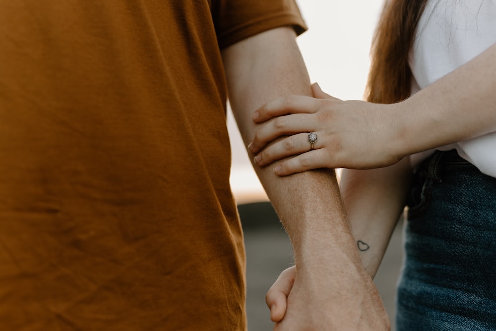 a close up of two people holding hands