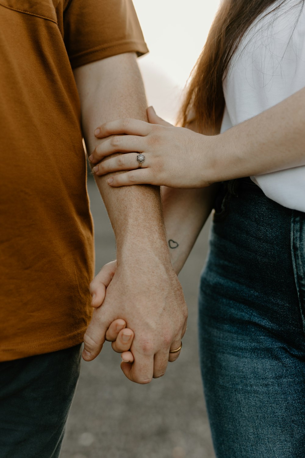 a couple holding hands while standing next to each other