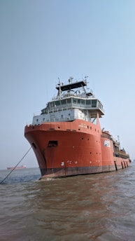 A sturdy vessel anchored near a dock, with a calm sea and a captain overseeing operations.