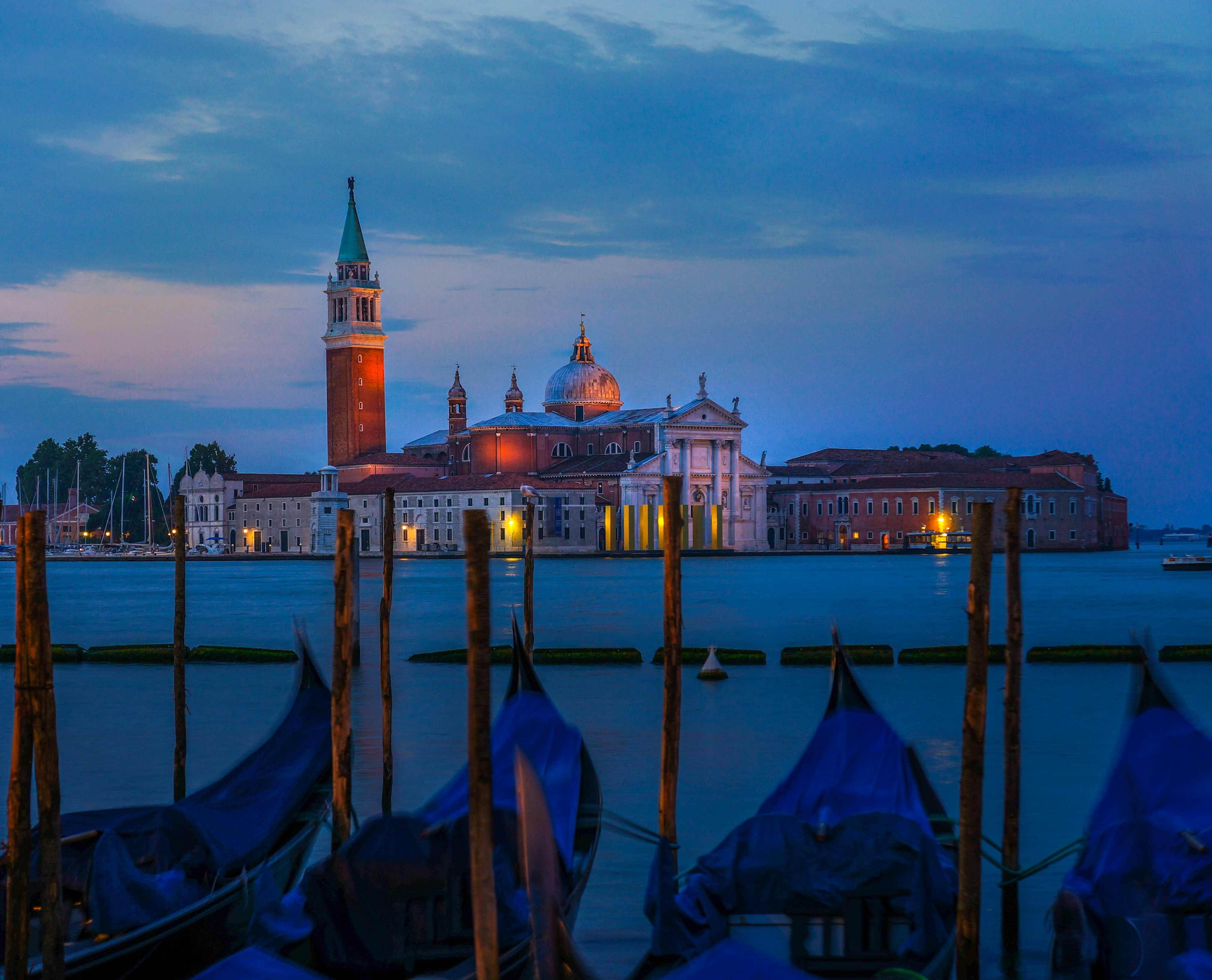 A group of gondolas sitting next to a body of water