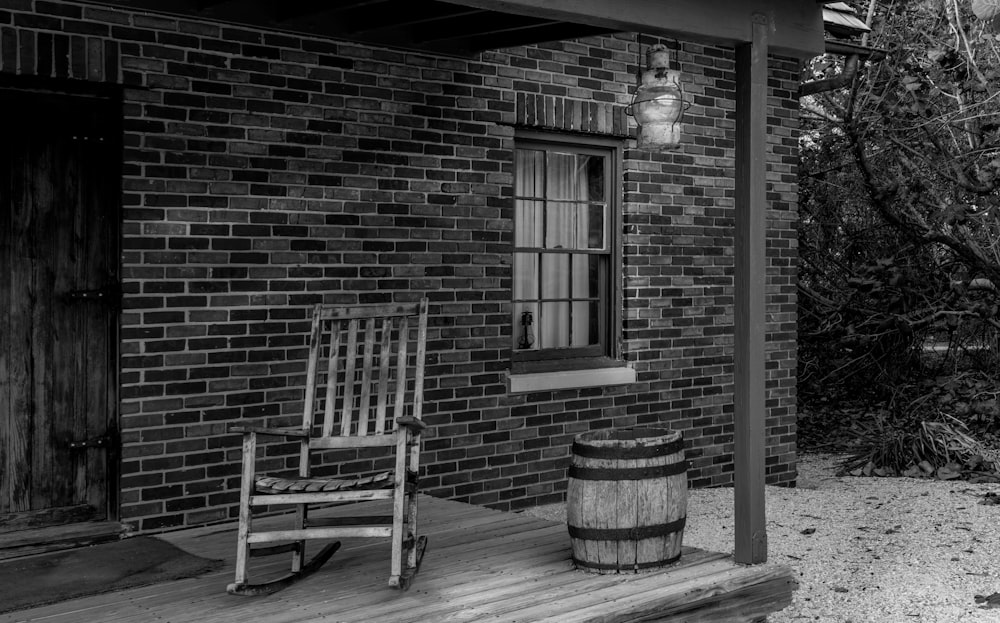 una mecedora de madera sentada encima de un porche de madera