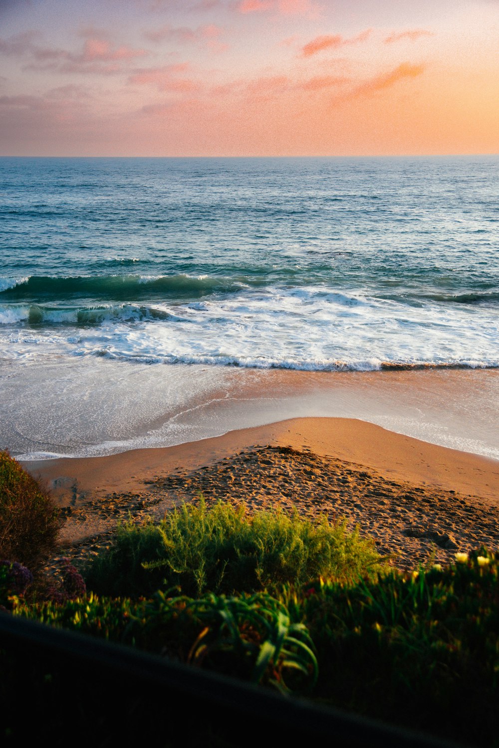 a view of a beach with waves coming in from the ocean