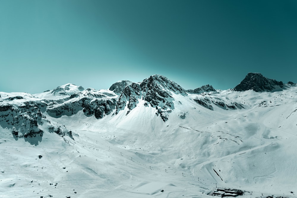 a mountain covered in snow with a sky background