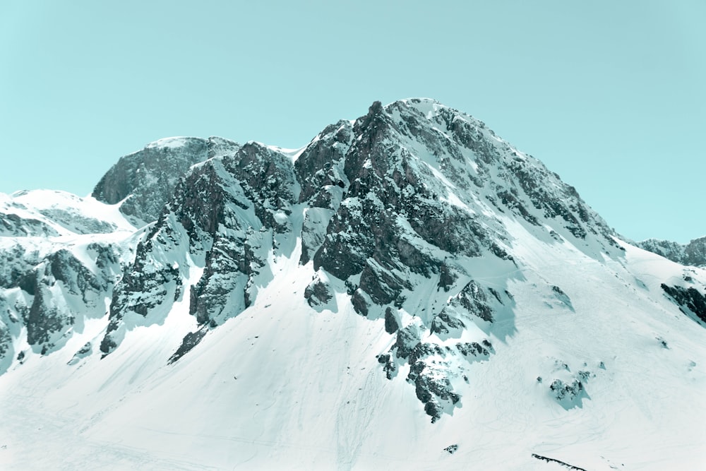 a mountain covered in snow with a sky background