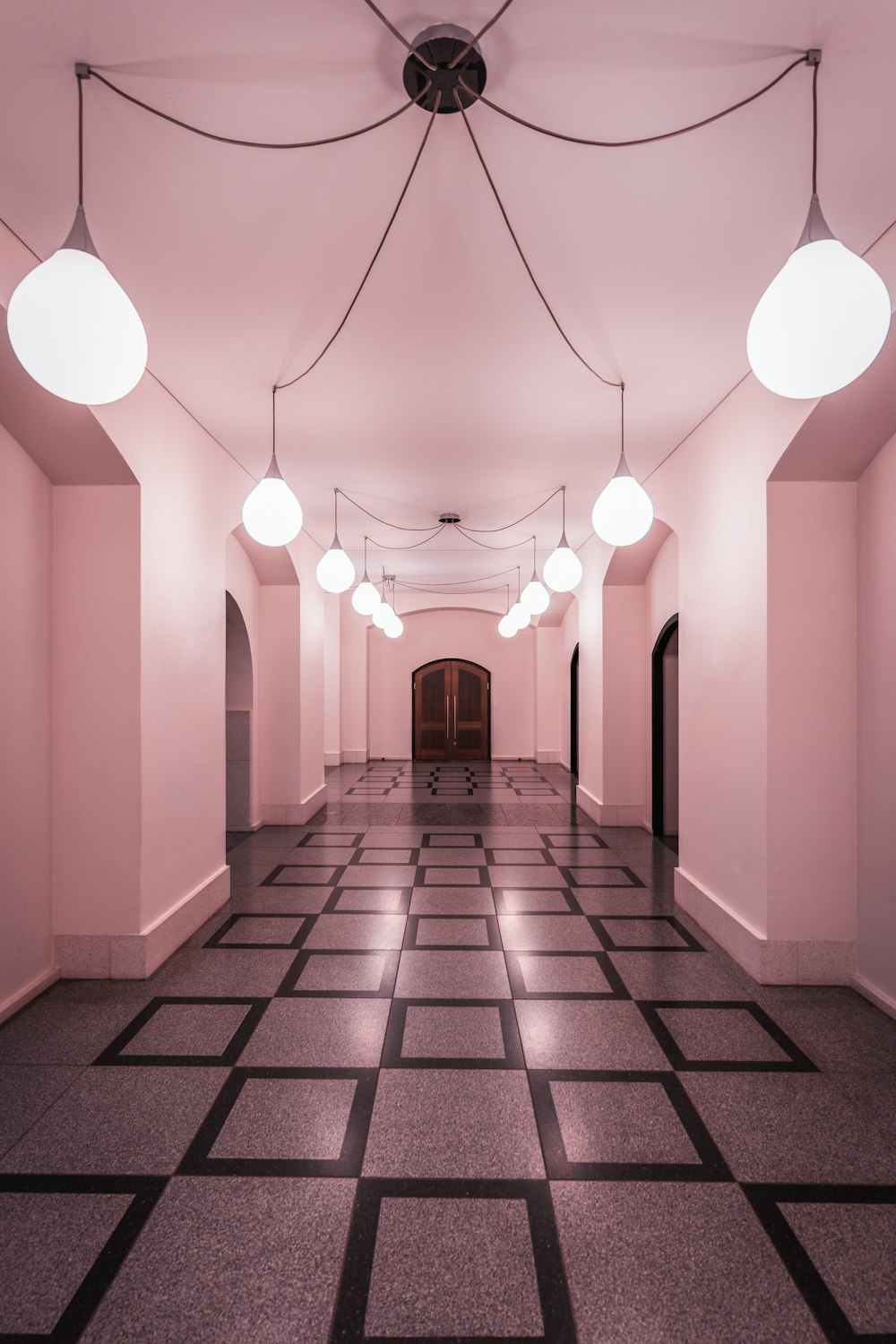 a long hallway with several lights hanging from the ceiling
