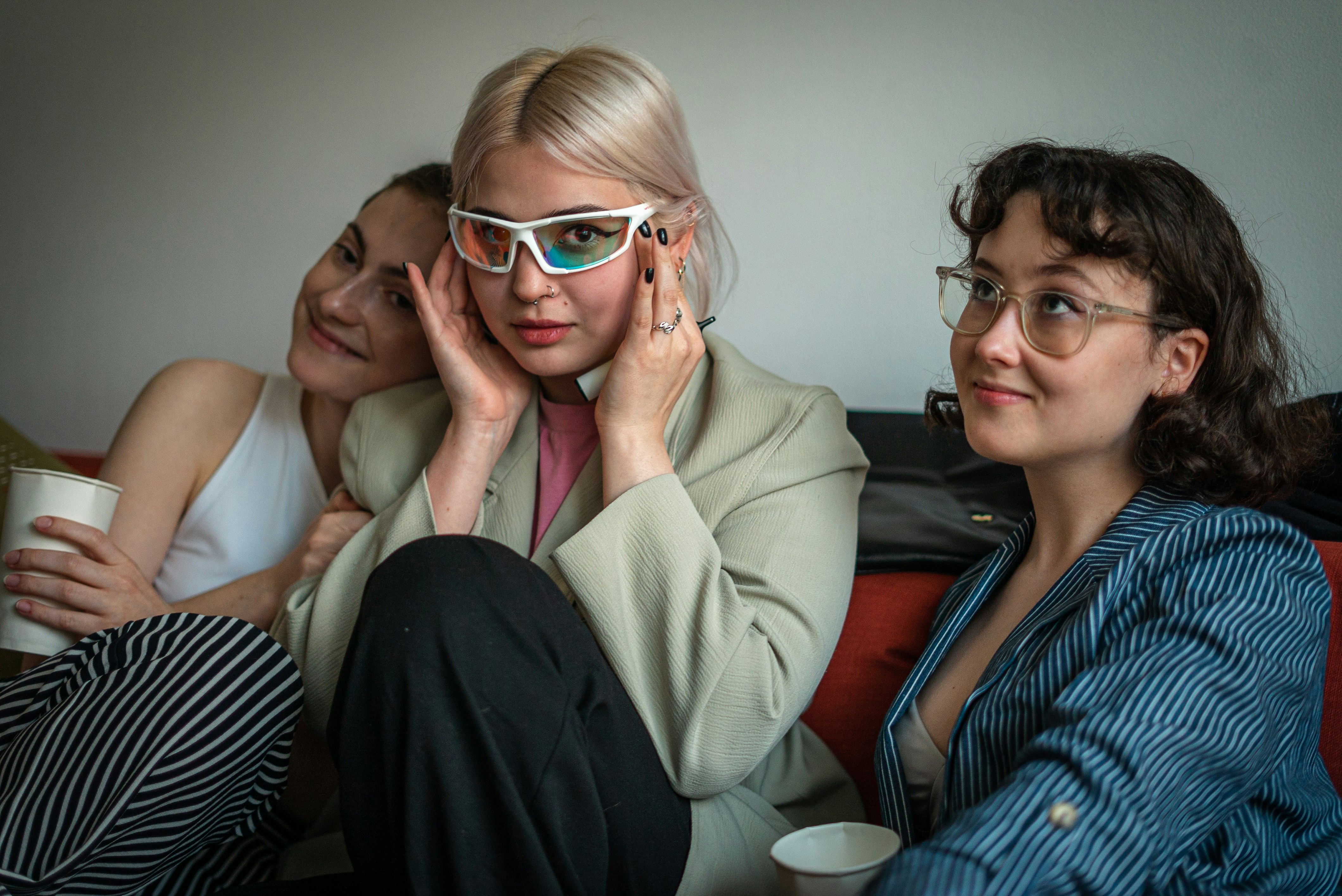 three women sitting on a couch wearing glasses