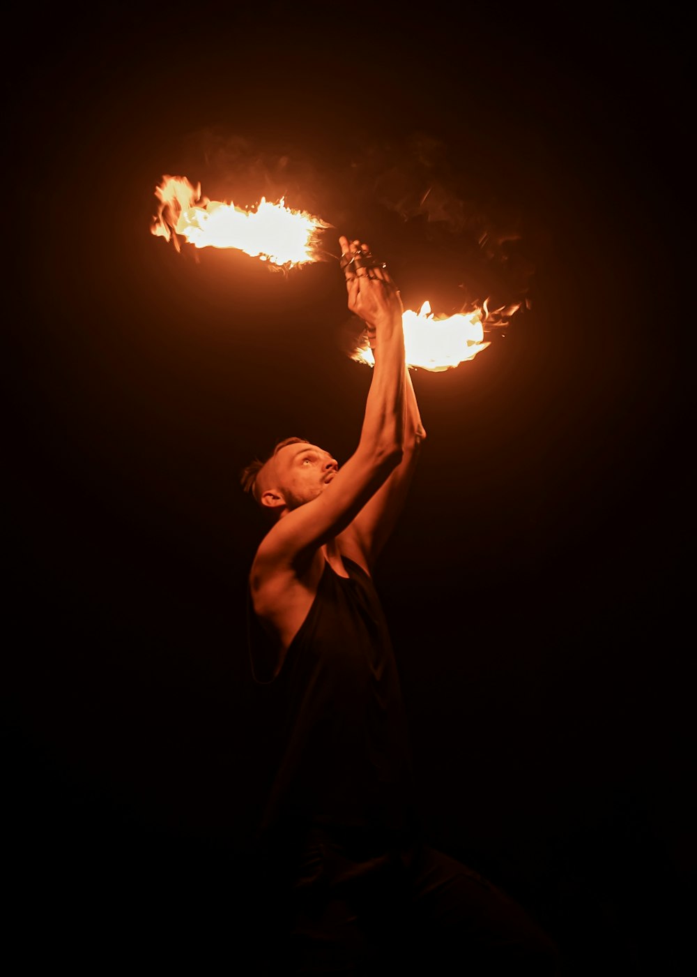 a man holding a fire stick in the dark