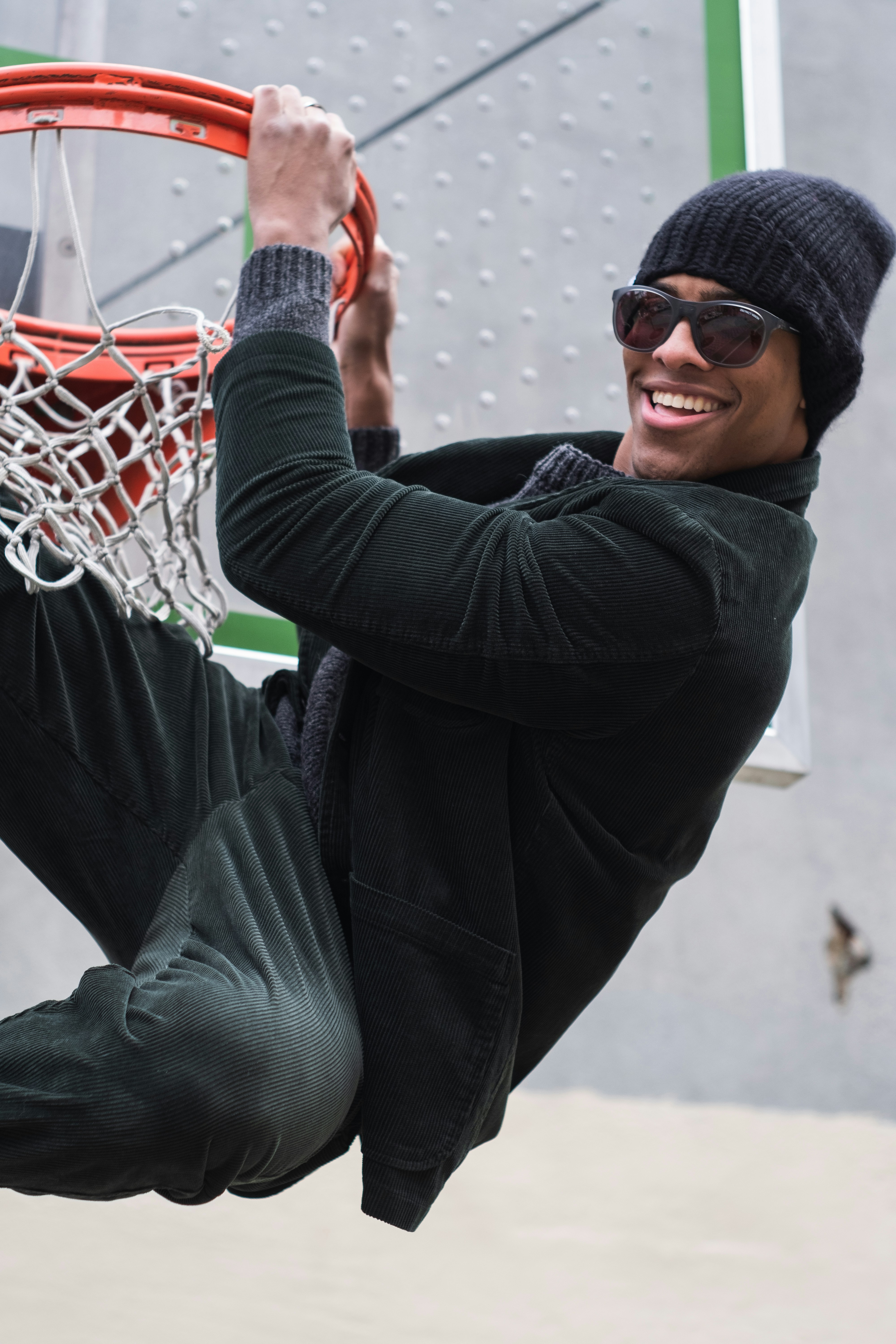 a man in a hat and sunglasses is playing basketball