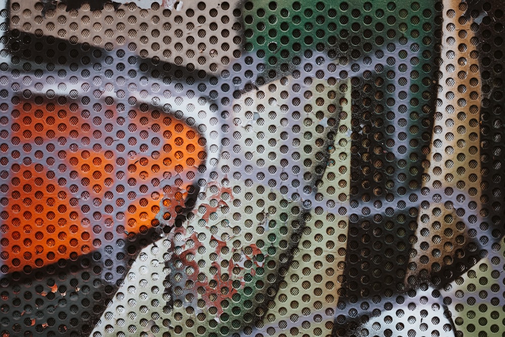 a close up of a colorful tie on a piece of metal