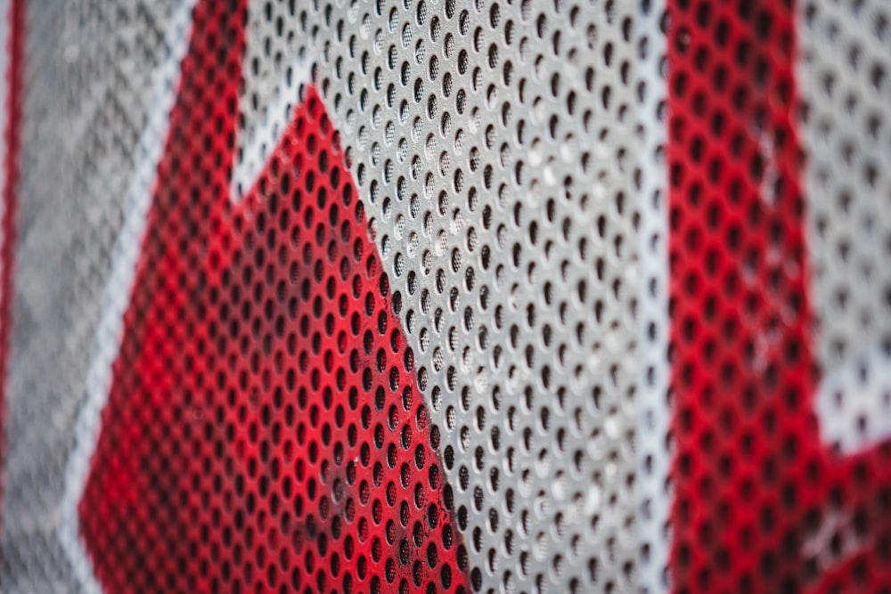 a close up of a red and white mesh
