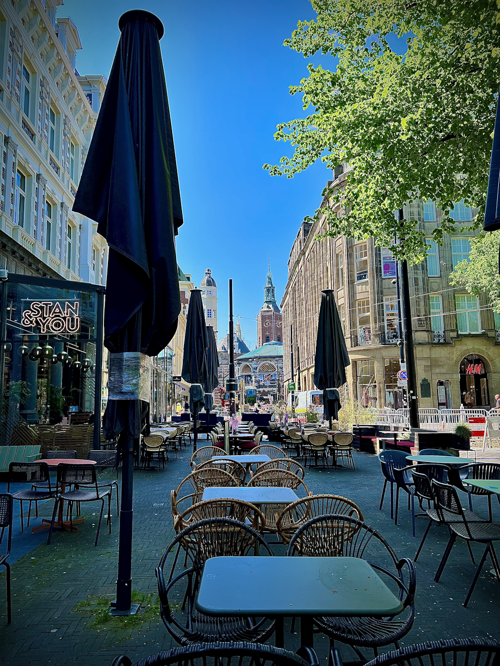 a row of tables and chairs sitting on a sidewalk