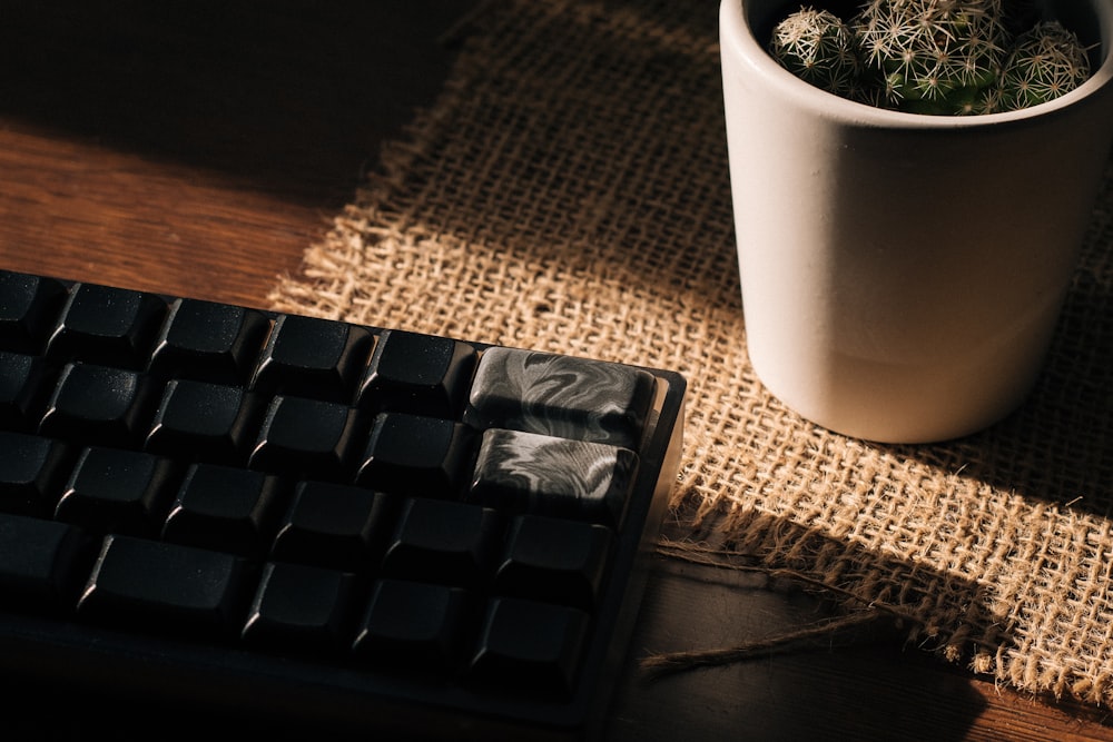 a coffee cup sitting next to a computer keyboard