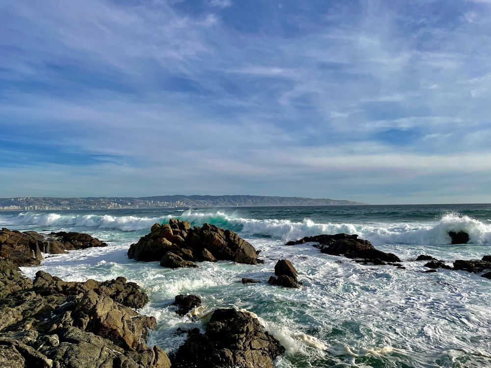 a rocky beach with waves crashing on the rocks