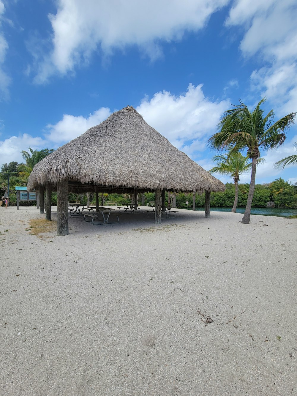 uma cabana com um telhado de palha em uma praia