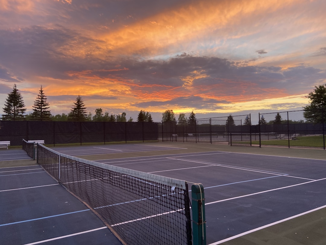 A sleek modern tennis court under sunset light, symbolizing focus and performance.