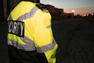 a man in a yellow jacket is standing in the dark