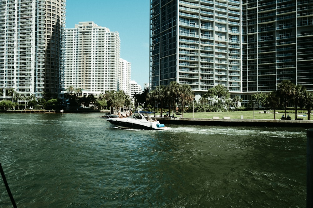 a boat traveling down a river next to tall buildings