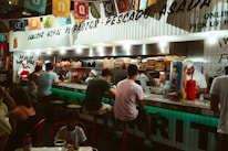 Cheerful staff serving sizzling fajitas to happy customers in a bright, airy dining room.