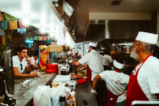 Aerial view of a bustling restaurant kitchen with delivery bags ready for pickup.