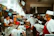 Smiling restaurant manager standing in front of a busy kitchen.