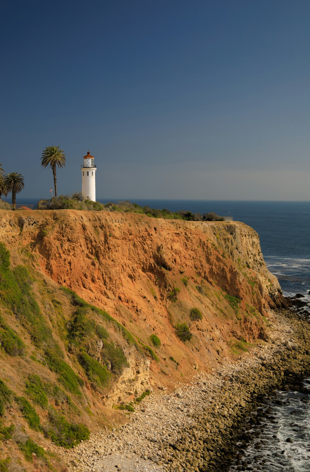 a lighthouse on a cliff overlooking the ocean