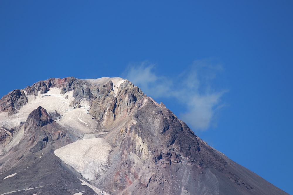 a very tall mountain covered in snow under a blue sky