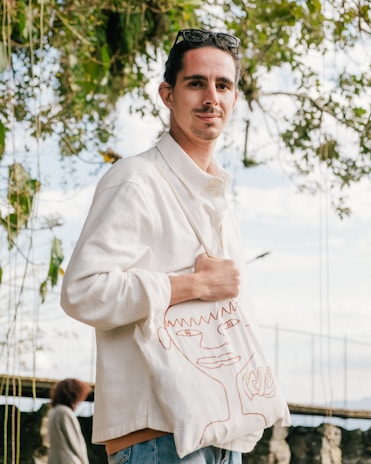 Smiling customer holding a personalized tote bag outdoors in natural light.
