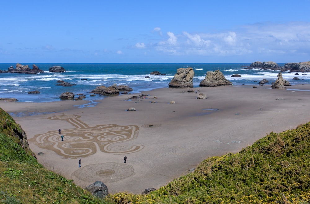 some people are standing on a beach near the water