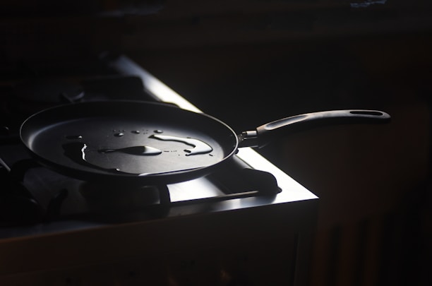 A close-up of a sleek, non-stick frying pan glowing with a warm, golden light.