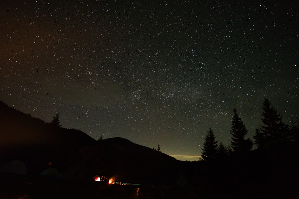 the night sky is filled with stars above a mountain