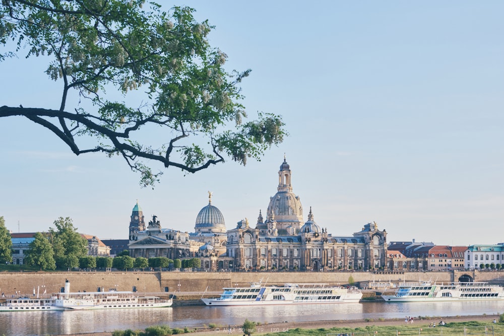 a river with a bunch of boats in front of a large building