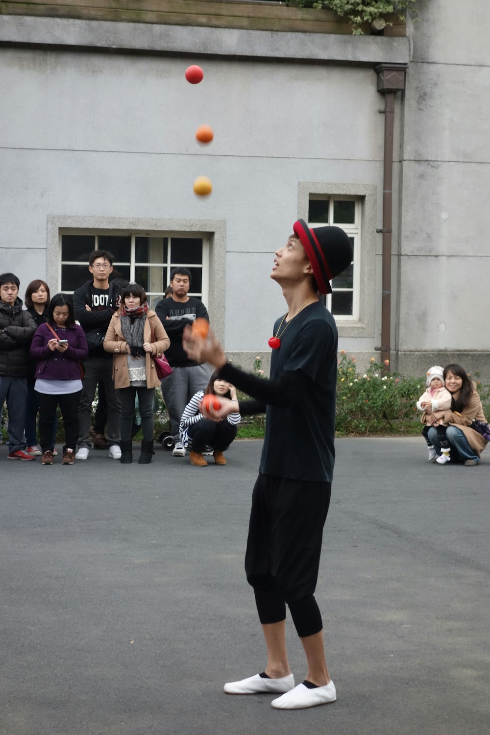 a person juggling balls in front of a group of people