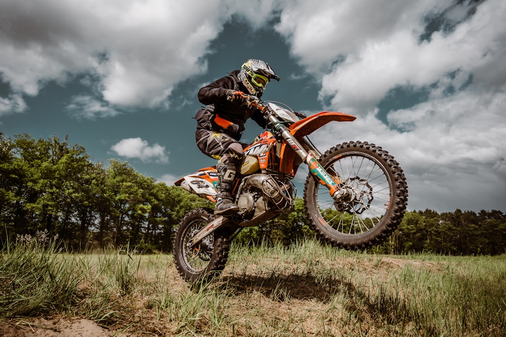 a man flying through the air while riding a motorcycle down a dirt road