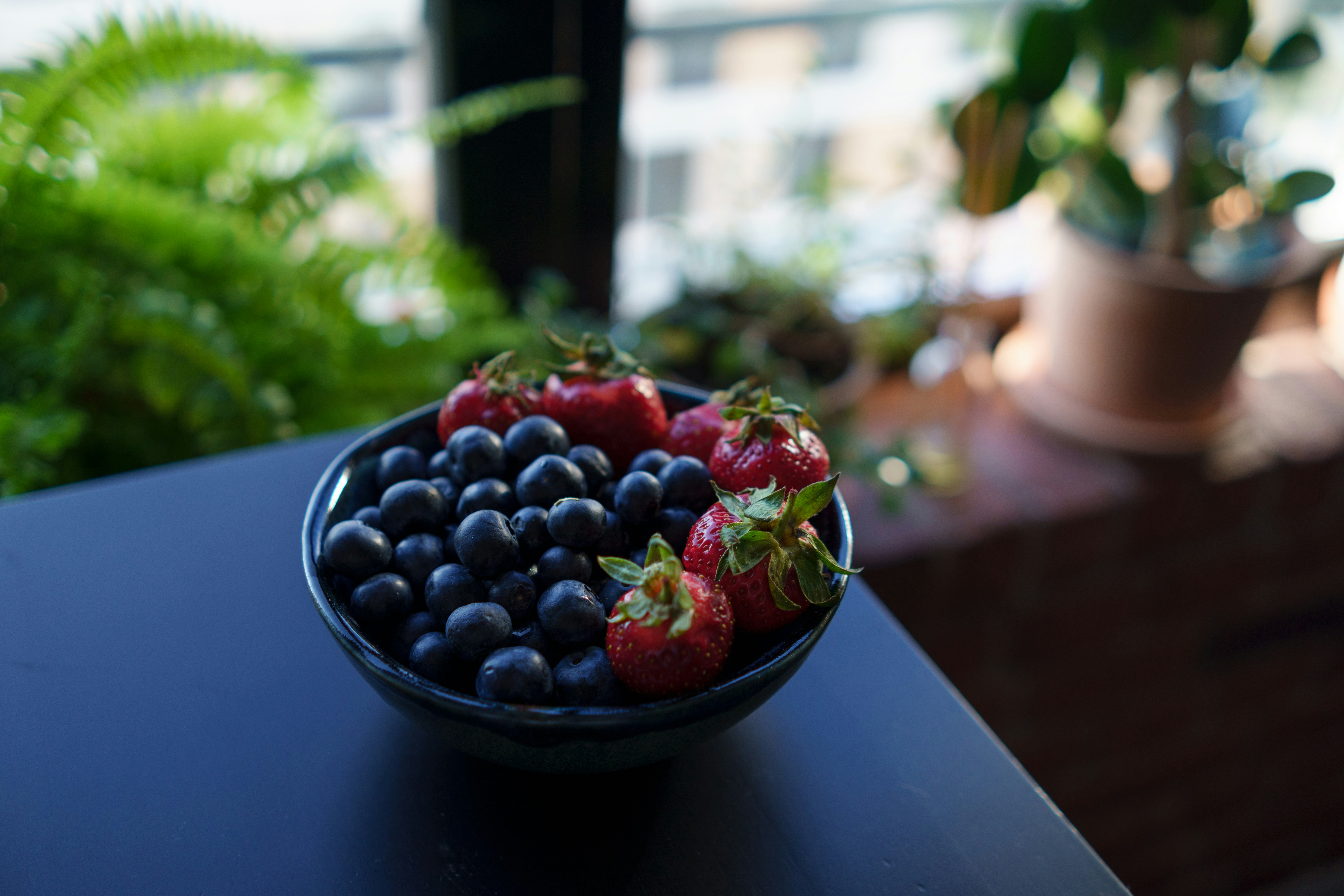 a bowl of strawberries and blueberries on a table