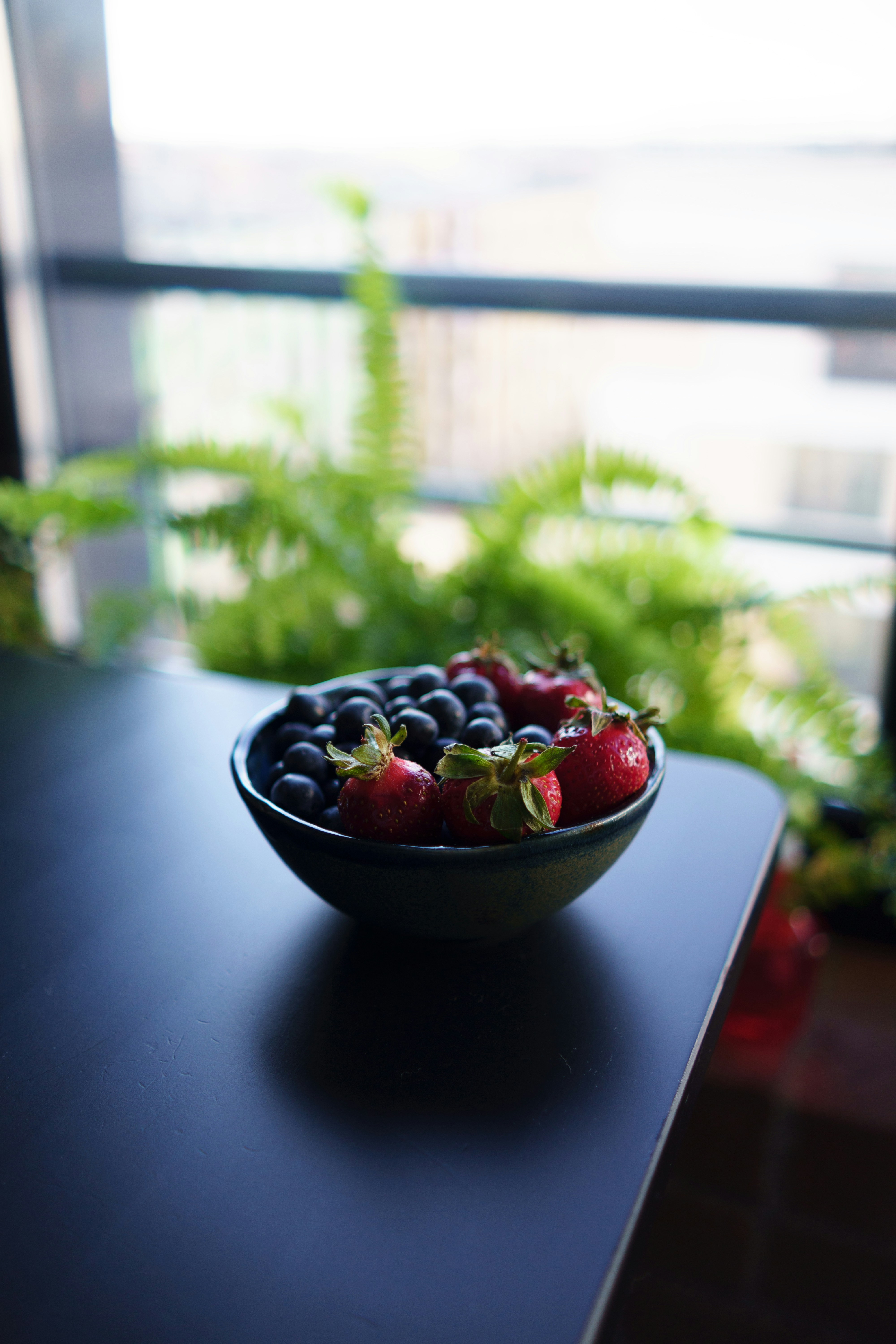 a bowl of strawberries and blueberries on a table
