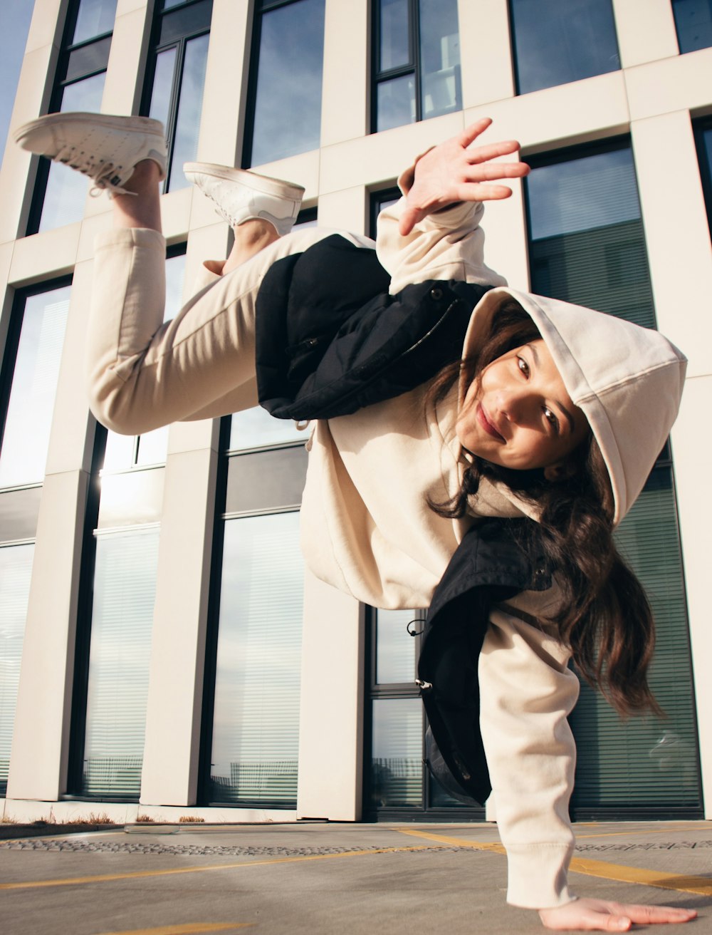 a woman doing a handstand in front of a building