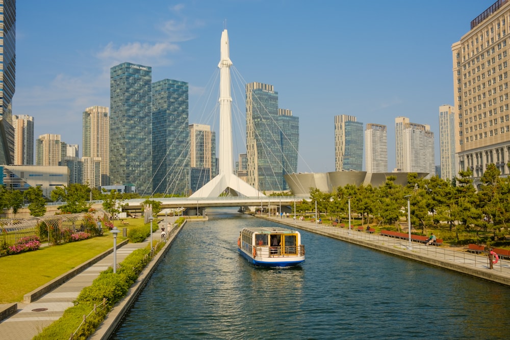 a boat traveling down a river next to tall buildings