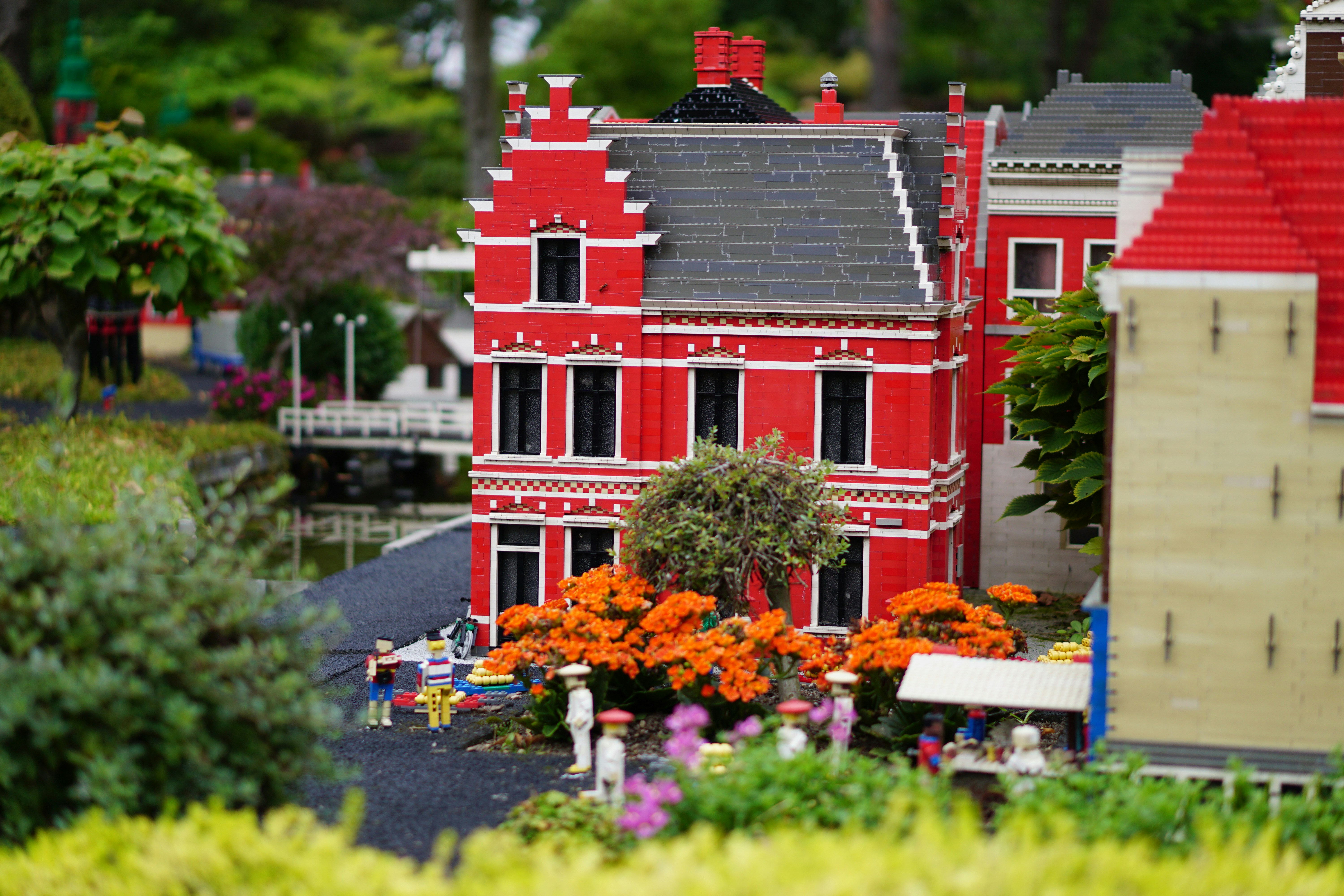 a model of a red house surrounded by flowers