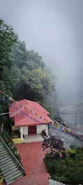 a small building with a red roof on a foggy day