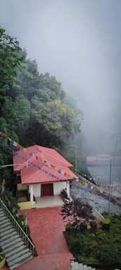 a small building with a red roof on a foggy day