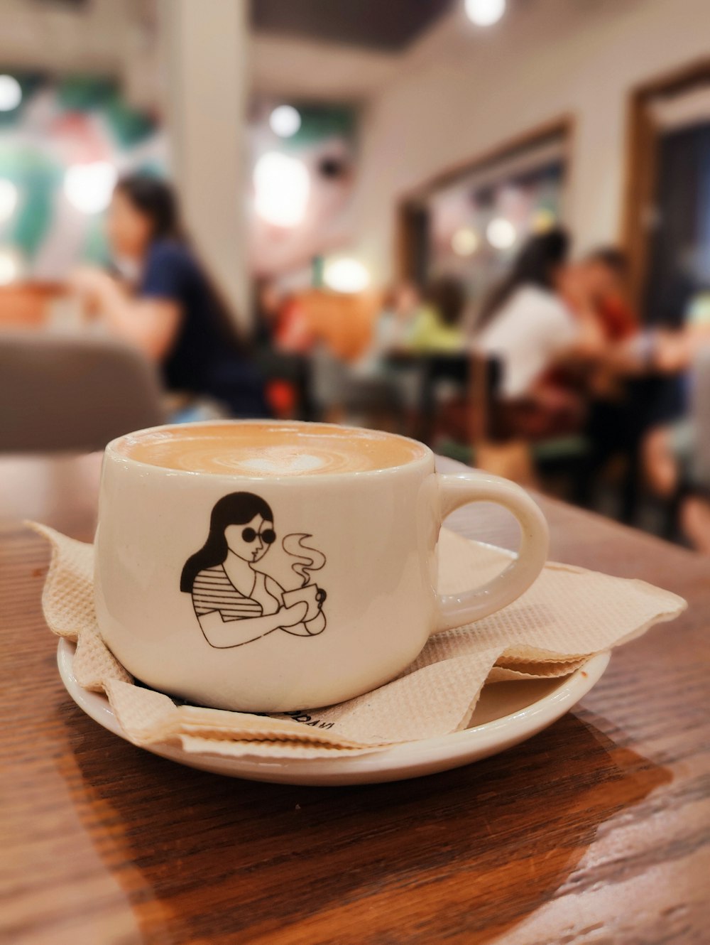 a cup of coffee with a drawing on it