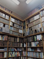 a bookshelf filled with lots of books in a library