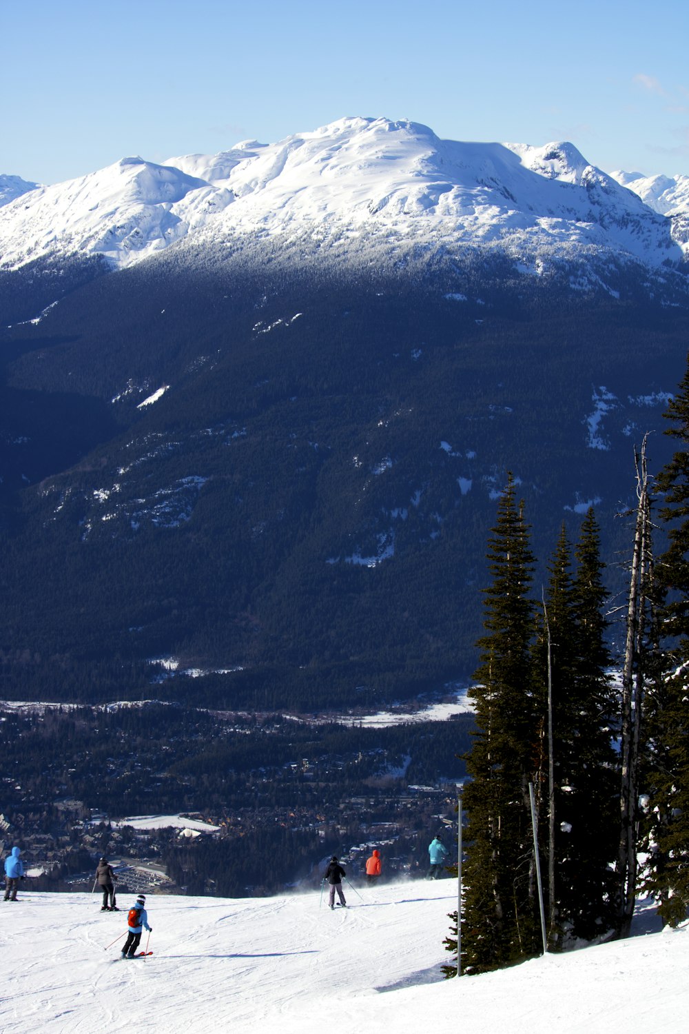 a group of people riding skis down a snow covered slope