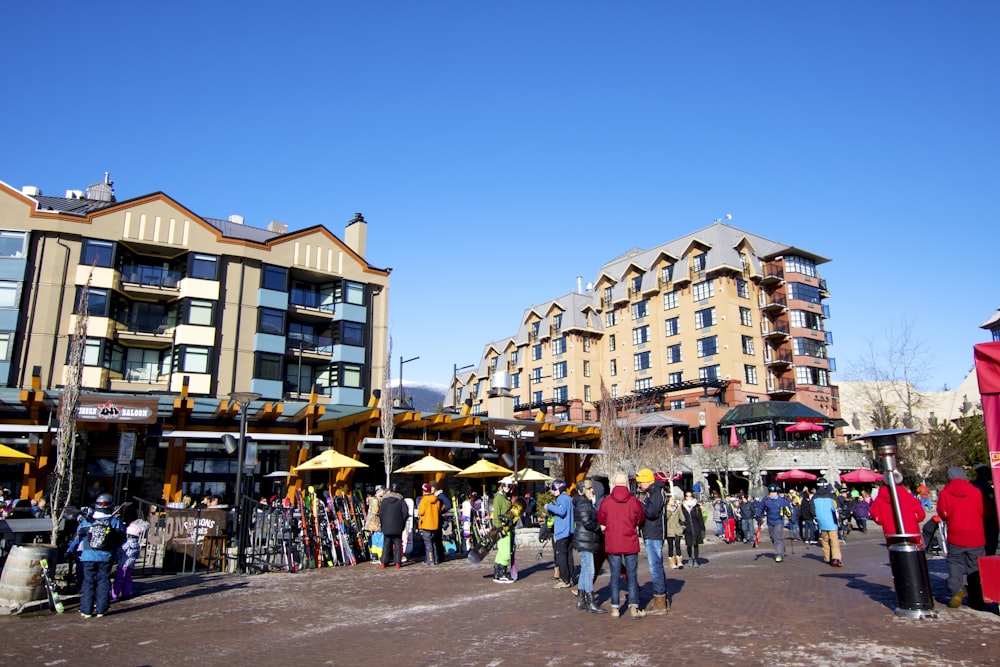 a group of people walking down a street next to tall buildings