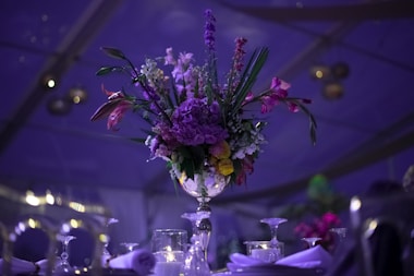 a vase filled with purple flowers on top of a table