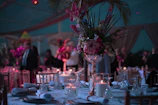 a table with a vase of flowers and candles on it