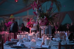 a table with a vase of flowers and candles on it